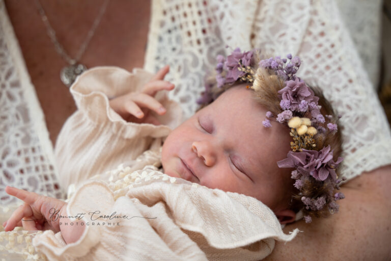 Séance photo naissance en studio à Morez : bébé endormi avec couronne de fleurs violettes