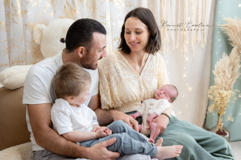 Séance photo naissance en studio à Morez : famille réunie avec le grand frère et le nouveau-né