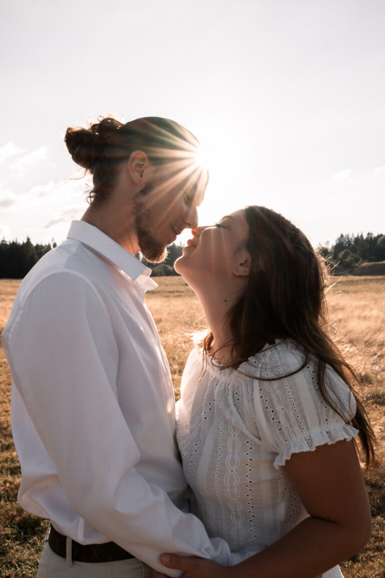 Séance photo couple dans le Jura : couple qui s’embrasse au soleil couchant