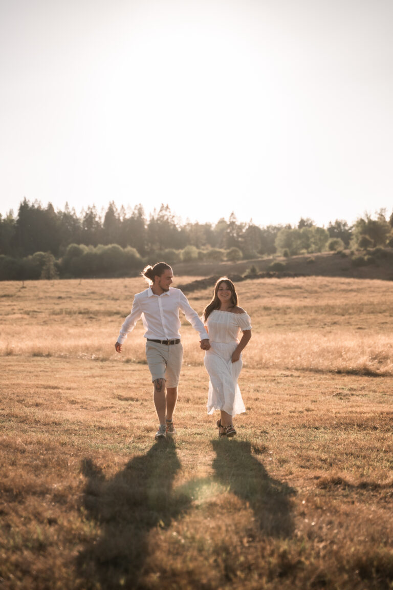 Séance photo couple dans le Jura : couple qui danse dans un champ au soleil couchant