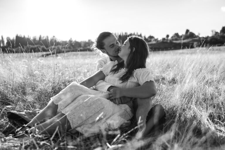 Séance photo couple dans le Jura : couple assis dans les herbes hautes, en noir et blanc