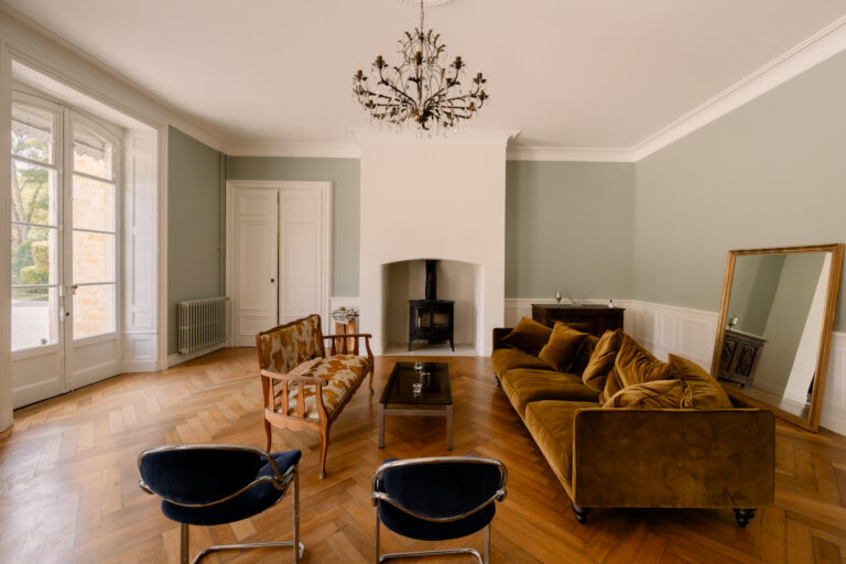 Photographe mariage Jura : salon du Château de Gevingey avec canapés et cheminée