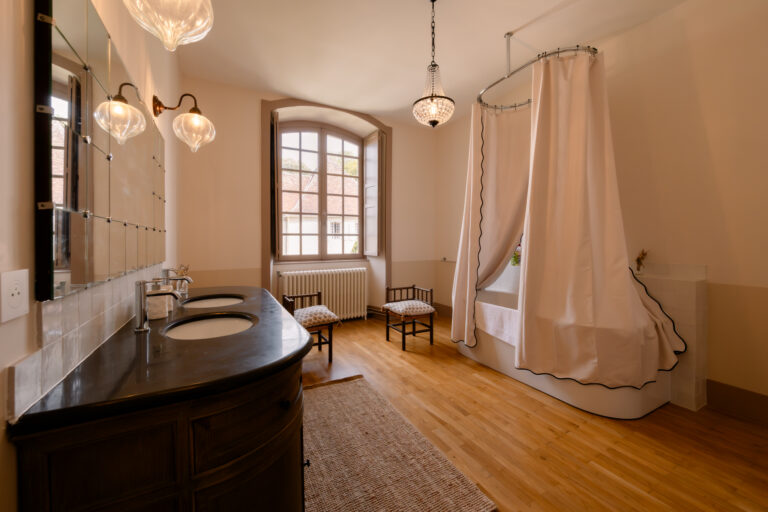 Photographe mariage Jura : salle de bain du château avec baignoire à rideaux
