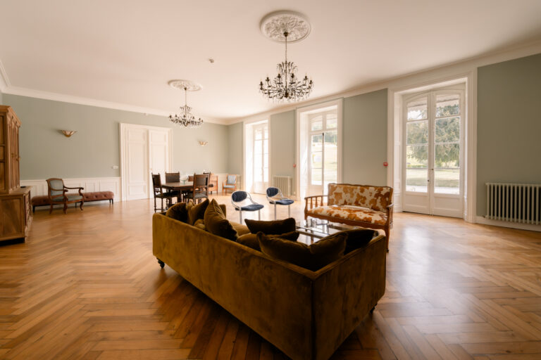 Photographe mariage Jura : grand salon lumineux du château, parquet et lustres