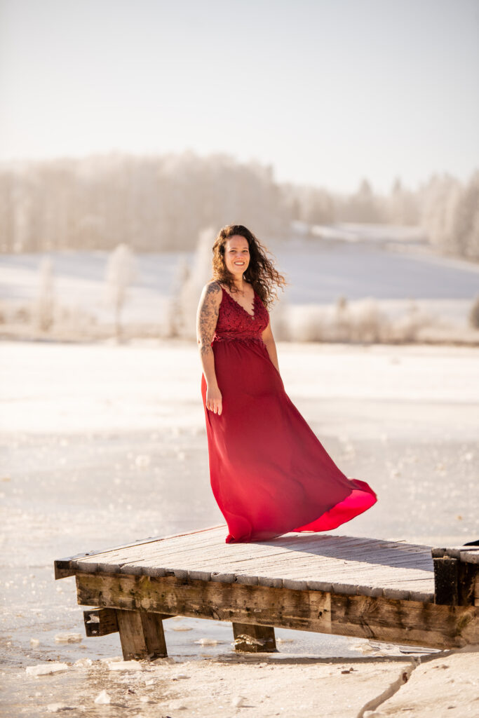 Photographe portrait Morez Jura Genève Lausanne Champagnole Lons-le-Saunier – femme en robe rouge sur un ponton enneigé