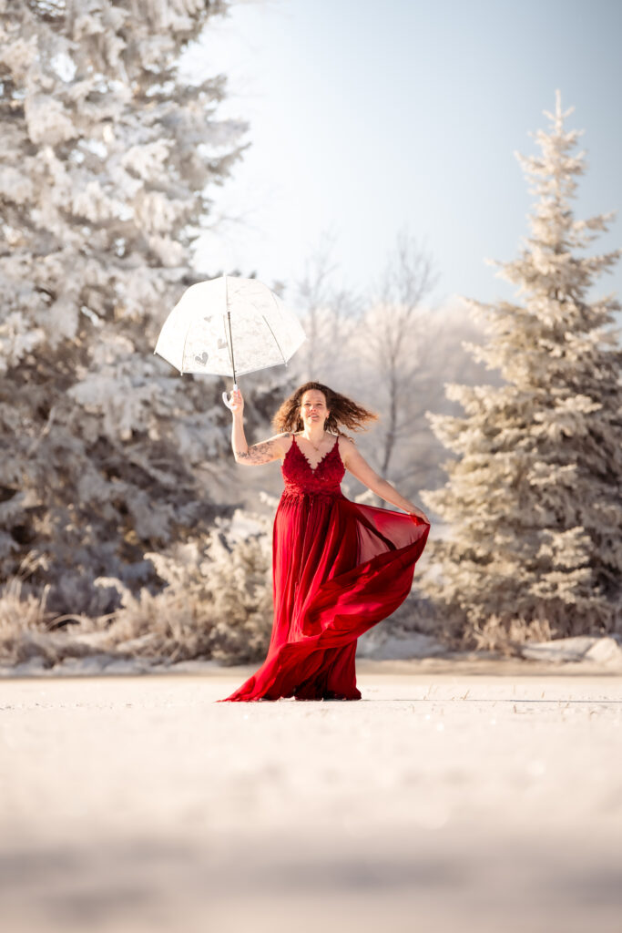 Photographe portrait Morez Jura Genève Lausanne Champagnole Lons-le-Saunier – femme en robe rouge avec une ombrelle blanche dans la neige