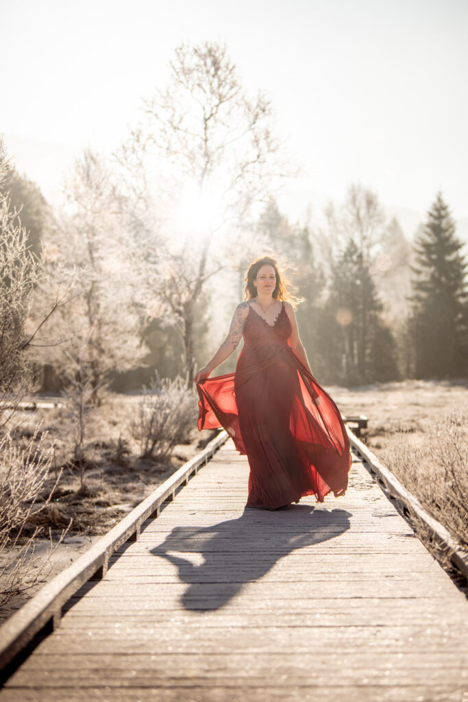 Photographe portrait Morez Jura Genève Lausanne Champagnole Lons-le-Saunier – femme en robe rouge sur une passerelle en bois givrée