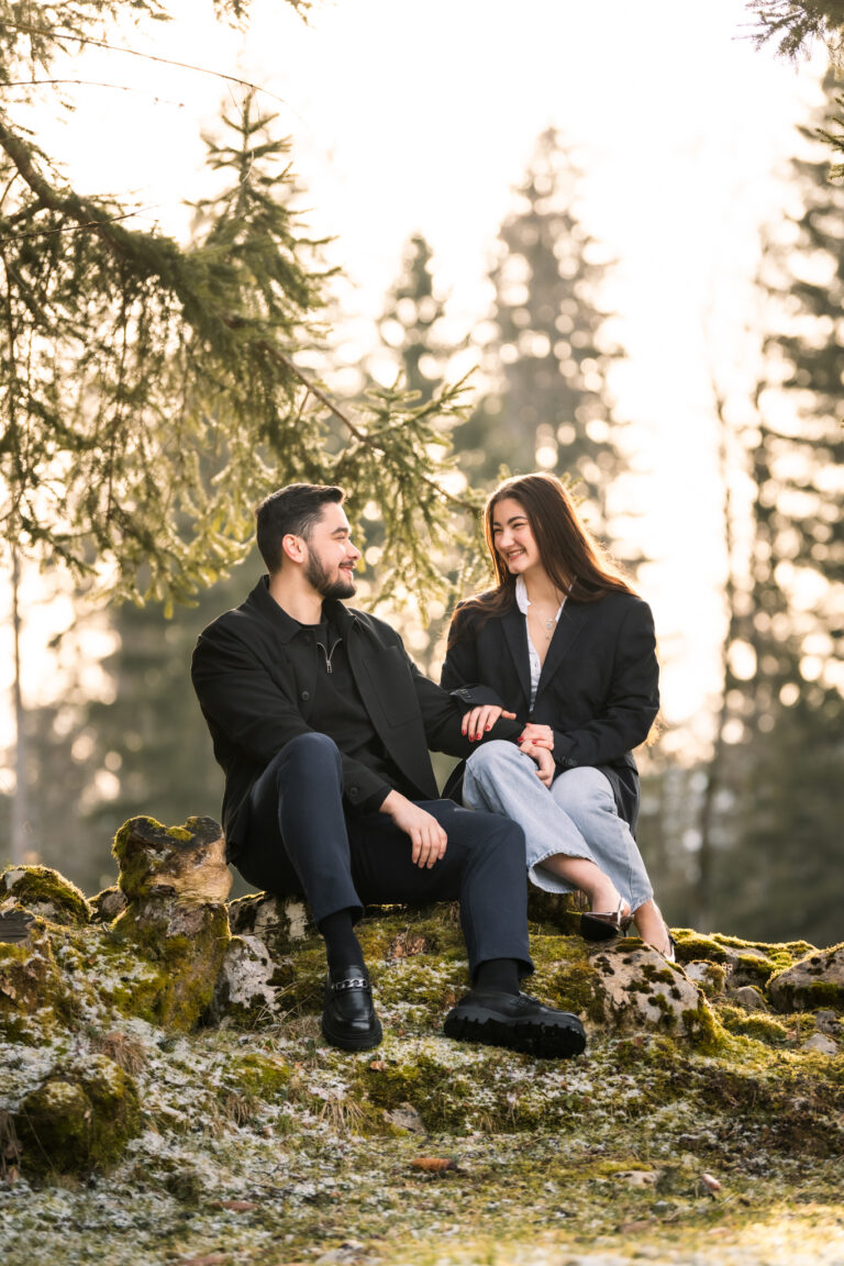 Photographe mariage couple Morez Jura Genève Lausanne Champagnole Lons-le-Saunier Besançon – couple complice assis sur un rocher en forêt