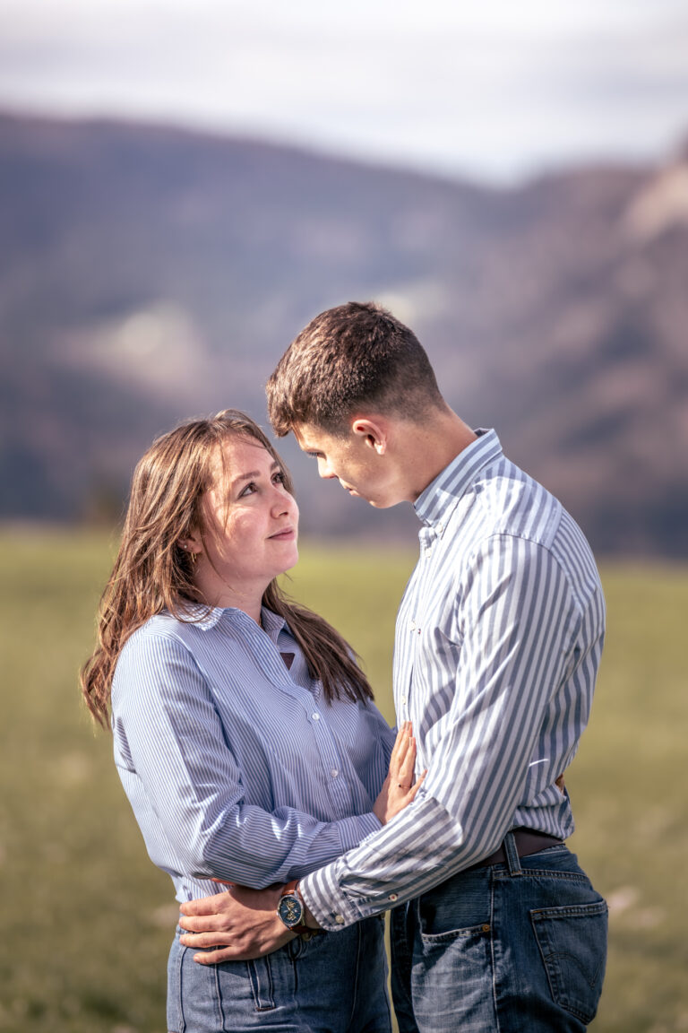 Photographe mariage couple Morez Jura Genève Lausanne Champagnole Lons-le-Saunier Besançon – couple enlacé dans un pré face aux montagnes