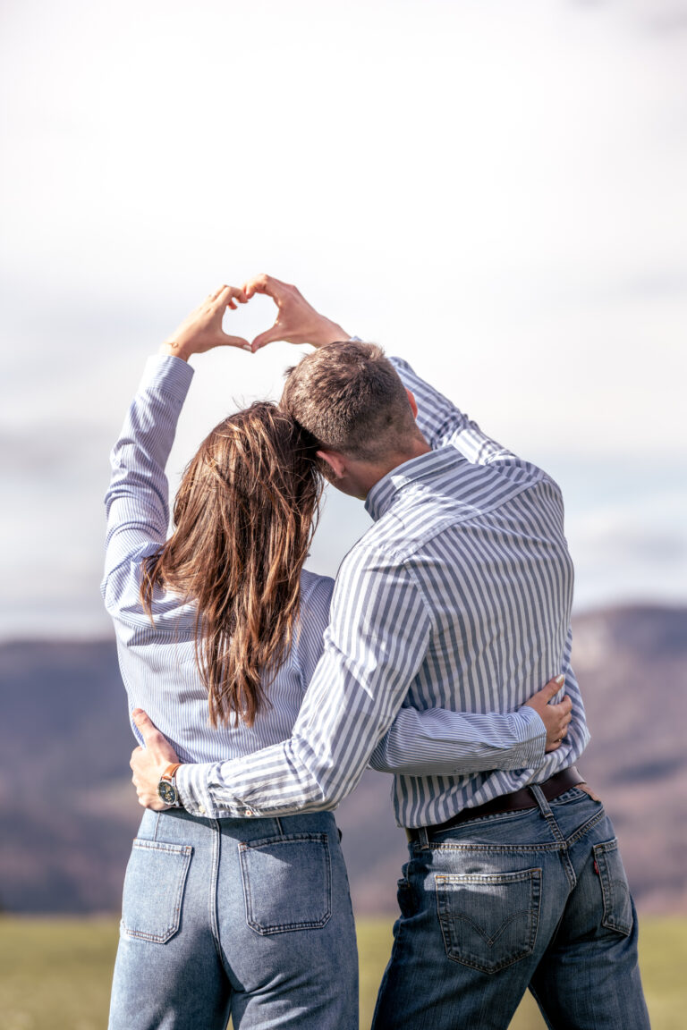 Photographe mariage couple Morez Jura Genève Lausanne Champagnole Lons-le-Saunier Besançon – couple formant un cœur avec leurs mains dans un pré