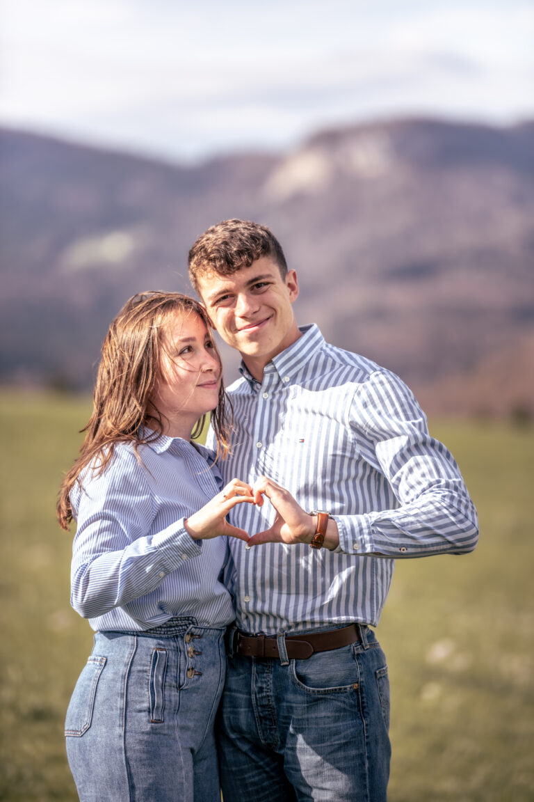 Photographe mariage couple Morez Jura Genève Lausanne Champagnole Lons-le-Saunier Besançon – couple formant un cœur avec leurs mains face aux montagnes