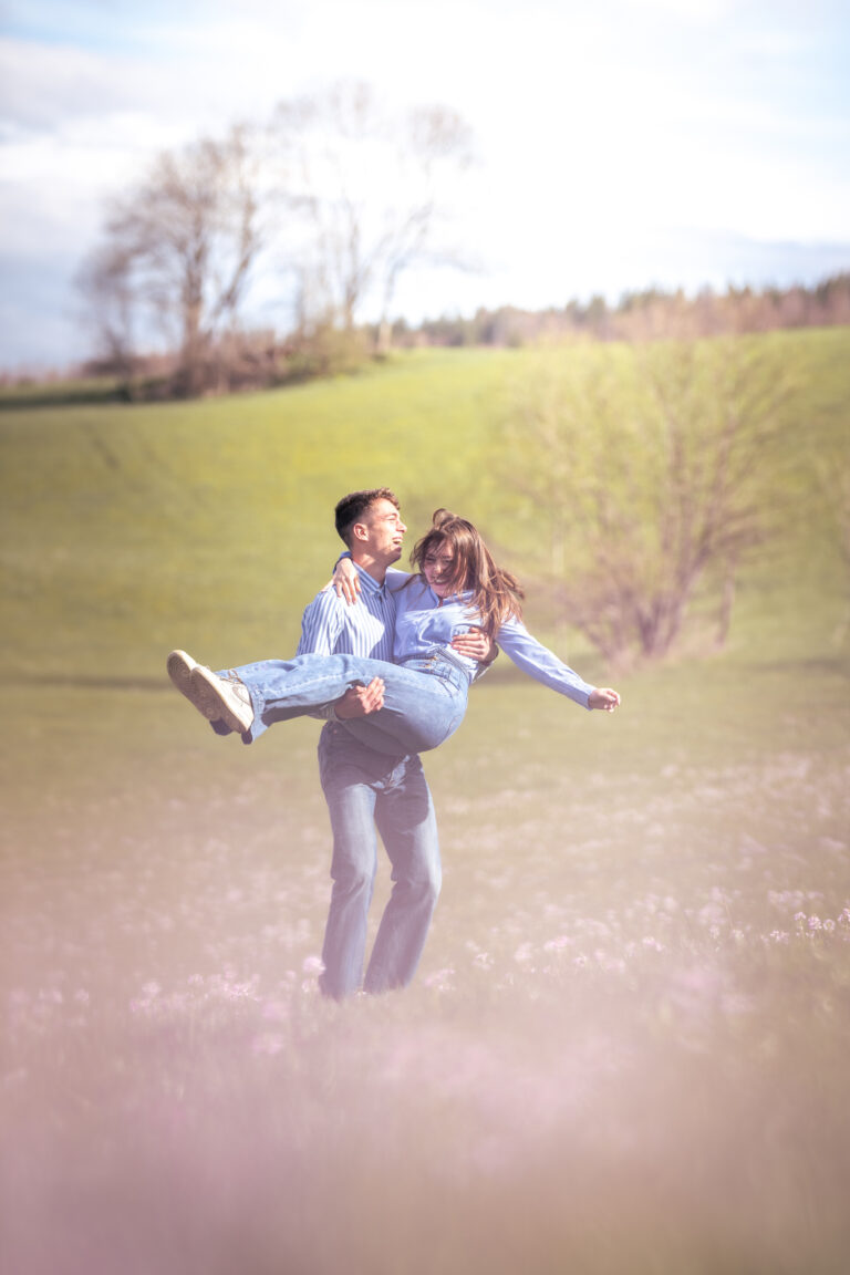 Photographe mariage couple Morez Jura Genève Lausanne Champagnole Lons-le-Saunier Besançon – homme portant sa compagne dans un pré fleuri