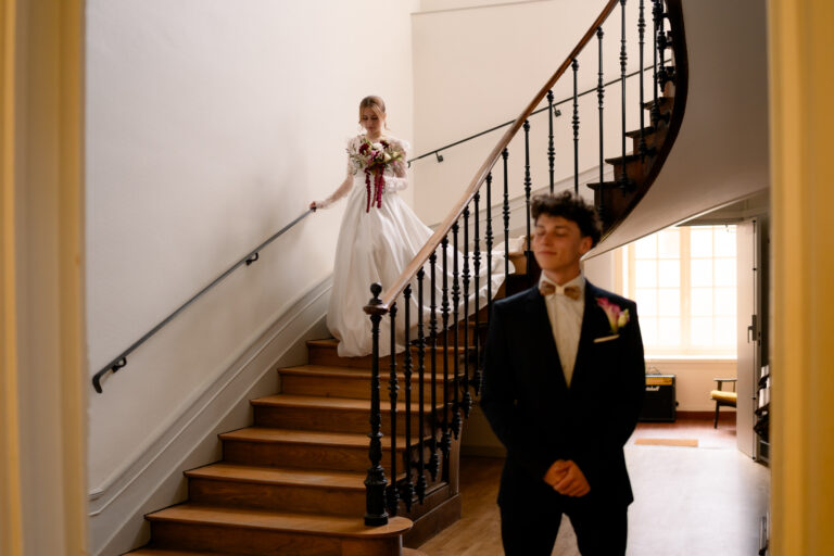 Photographe mariage Jura : marié qui attend sa mariée au pied de l’escalier