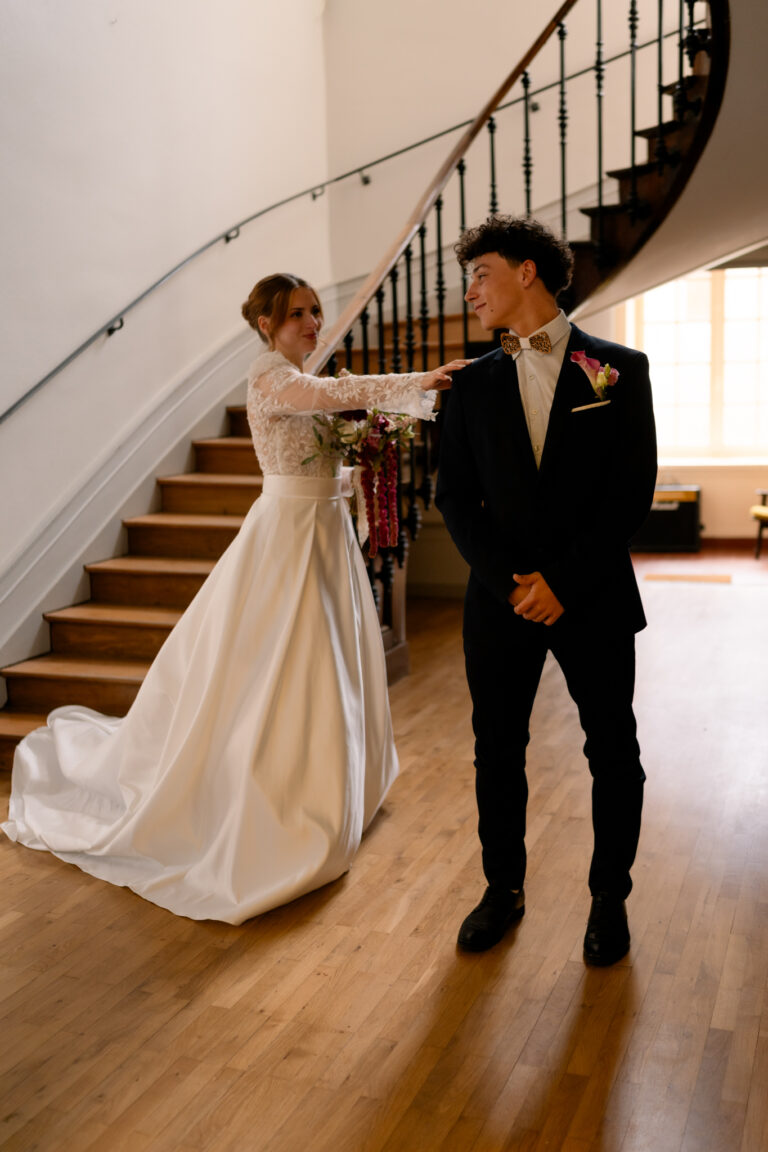 Photographe mariage Jura : mariée qui touche l’épaule du marié pour le first look