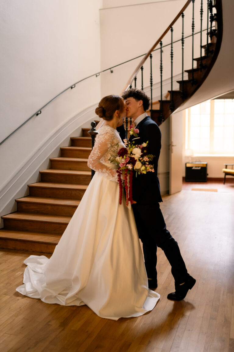 Photographe mariage Jura : mariés enlacés au pied de l’escalier