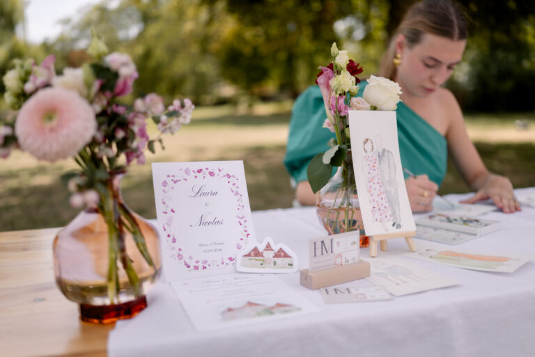 Photographe mariage Jura : aquarelliste qui peint à sa table dans le parc