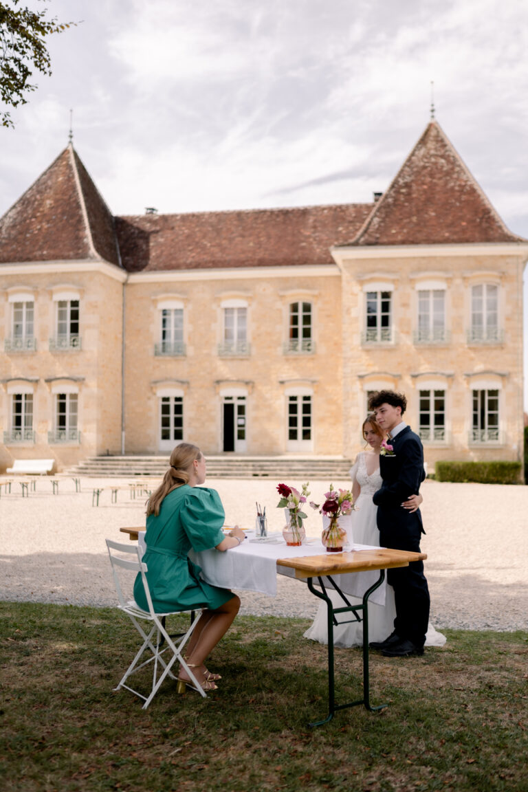 Photographe mariage Jura : mariés qui posent pour l’aquarelliste devant le château