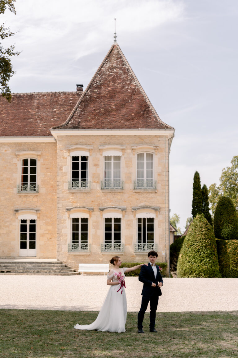 Photographe mariage Jura : marié qui attend sa mariée devant la façade du château