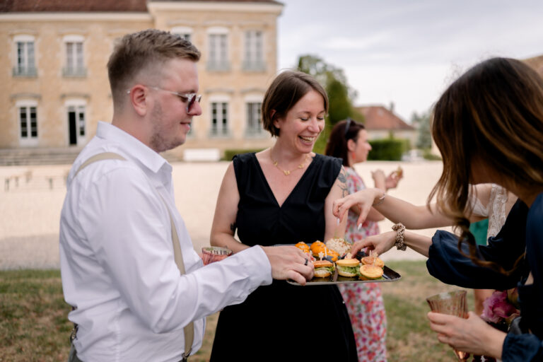 Photographe mariage Jura : invités qui goûtent les bouchées du traiteur