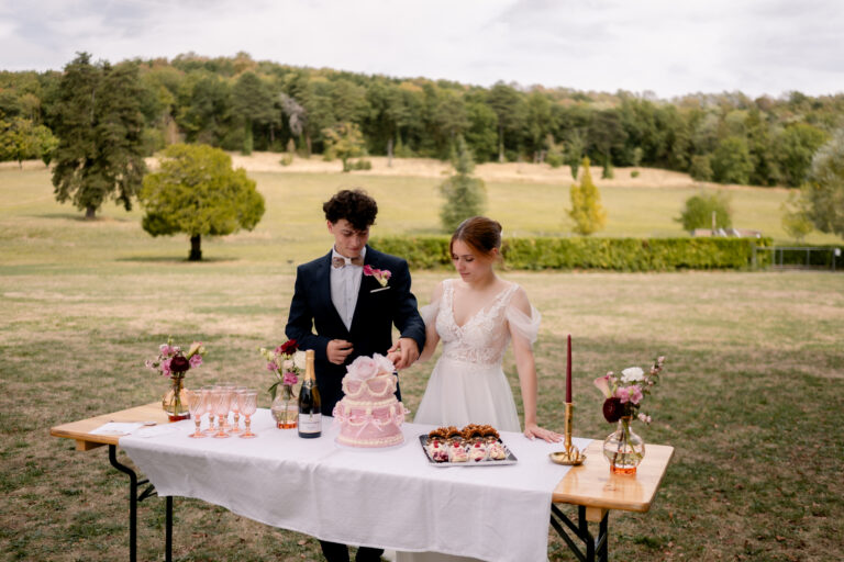 Photographe mariage Jura : mariés au buffet de desserts dans le parc du château