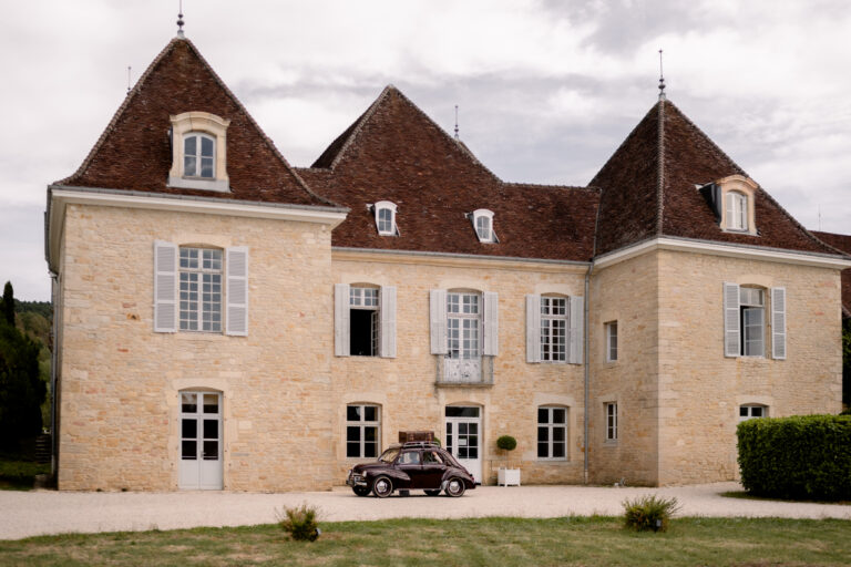 Photographe mariage Jura : façade du Château de Gevingey avec une voiture ancienne
