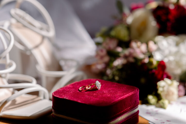 Photographe mariage Jura : écrin rouge, bague, chaussures et fleurs de la mariée