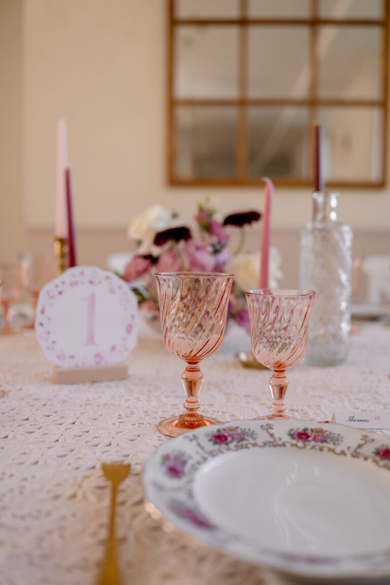 Photographe mariage Jura : table rose avec menu aquarelle et verres colorés
