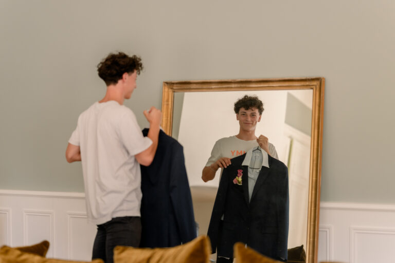 Photographe mariage Jura : marié qui décroche son costume devant le miroir