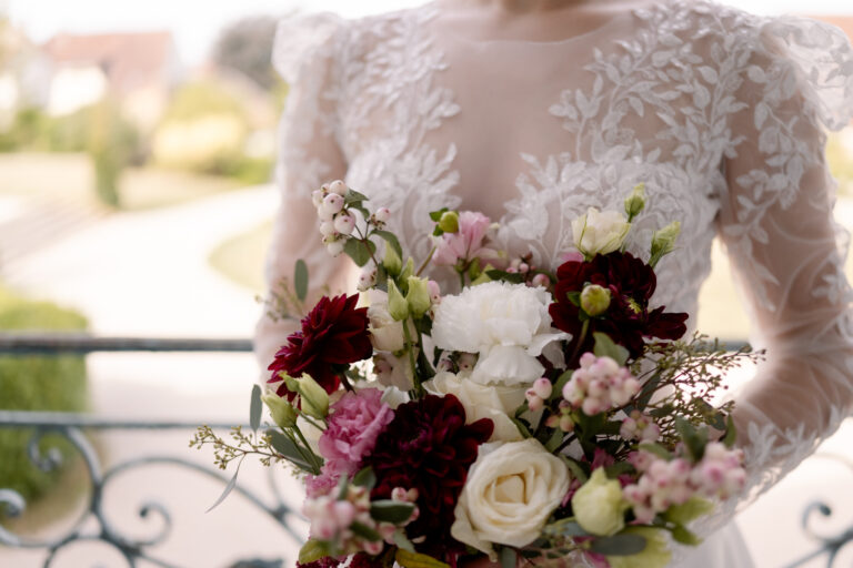 Photographe mariage Jura : bouquet de la mariée en roses blanches et fleurs bordeaux