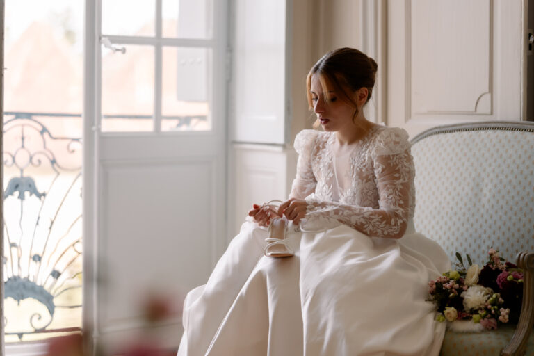 Photographe mariage Jura : mariée assise qui attache ses chaussures