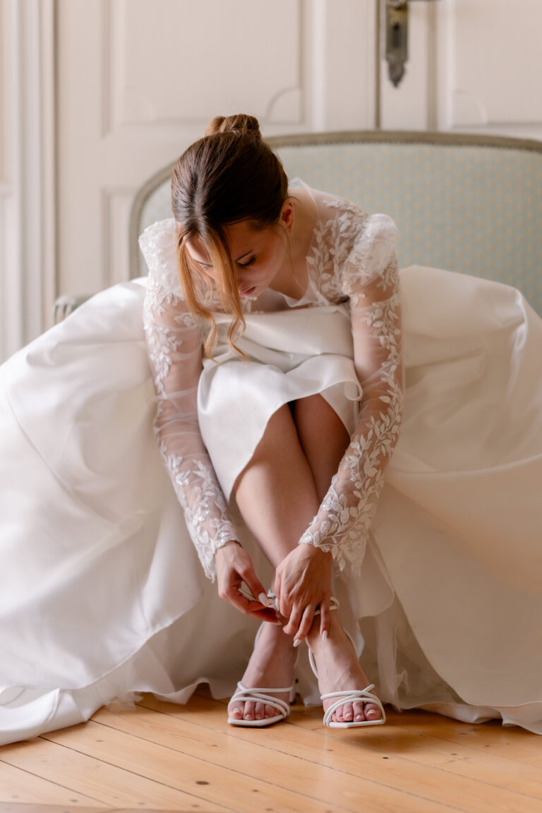 Photographe mariage Jura : mariée assise qui attache ses chaussures