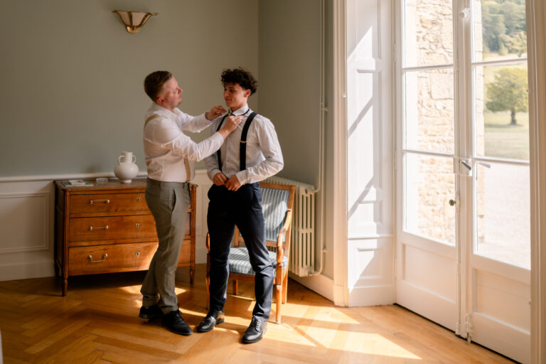 Photographe mariage Jura : marié qui se prépare avec un proche