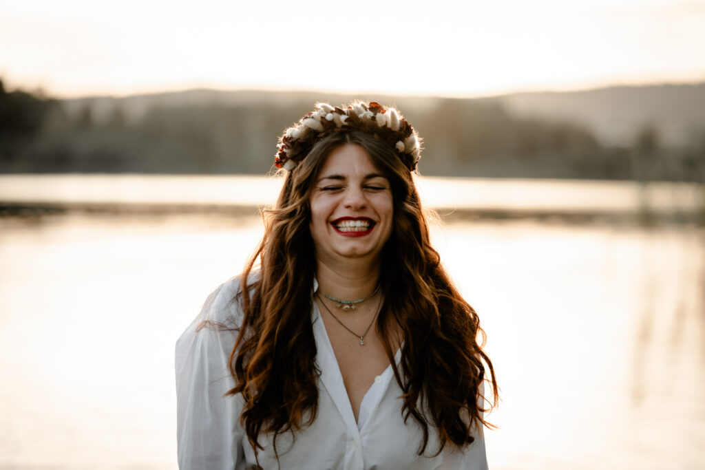 Photographe portrait Morez Jura Genève Lausanne Champagnole Lons-le-Saunier – femme souriante avec couronne de fleurs au bord d’un lac