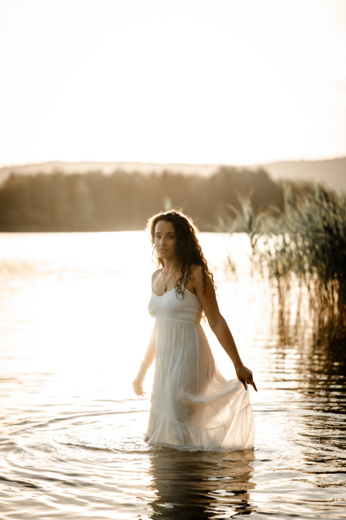 Photographe portrait Morez Jura Genève Lausanne Champagnole Lons-le-Saunier – femme en robe blanche marchant dans l’eau d’un lac