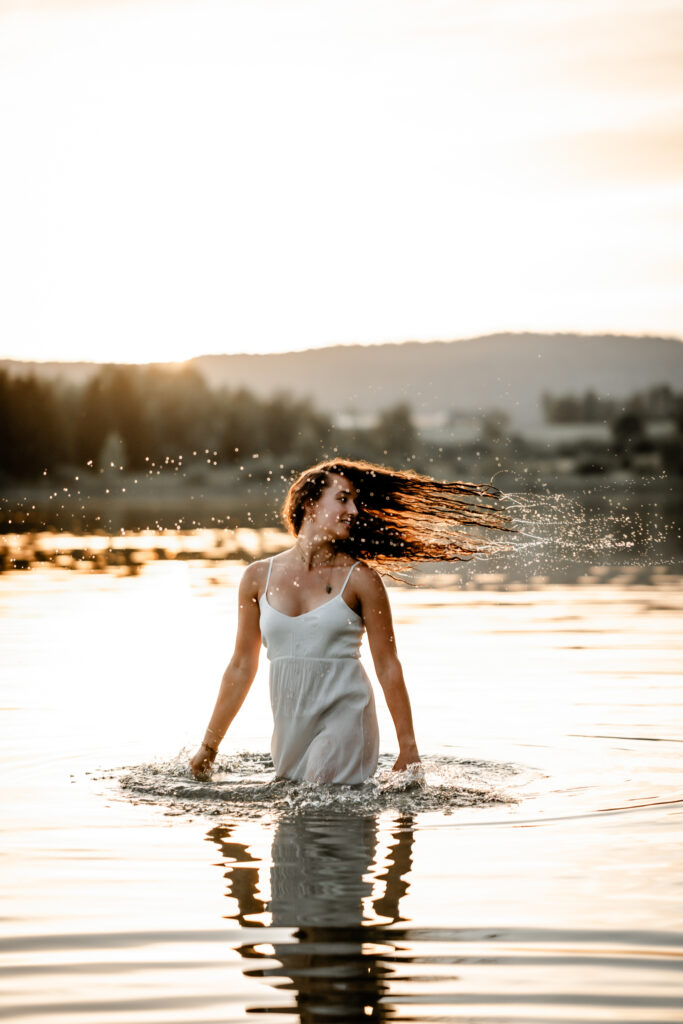 Photographe portrait Morez Jura Genève Lausanne Champagnole Lons-le-Saunier – femme en robe blanche dans un lac, cheveux au vent