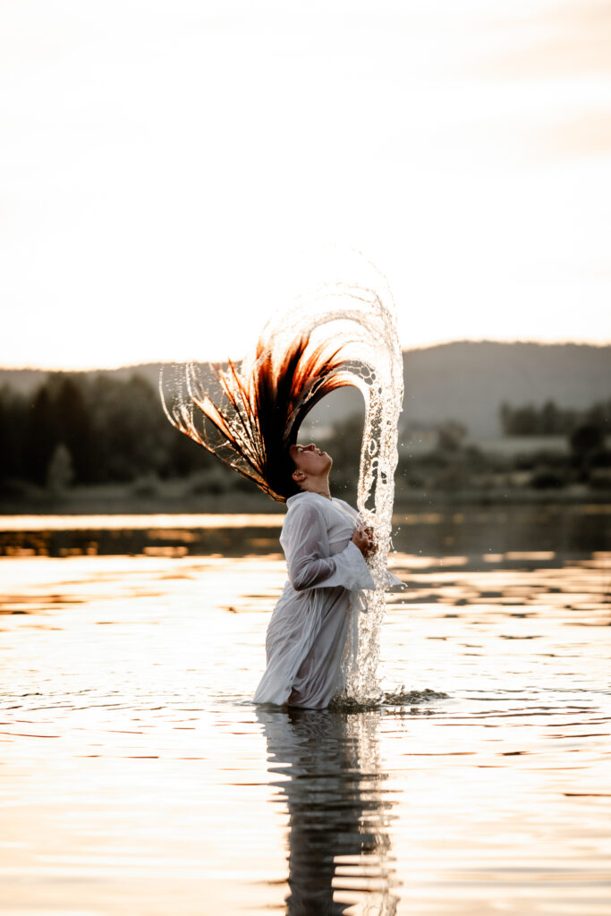 Photographe portrait Morez Jura Genève Lausanne Champagnole Lons-le-Saunier – femme projetant ses cheveux dans l’eau à contre-jour