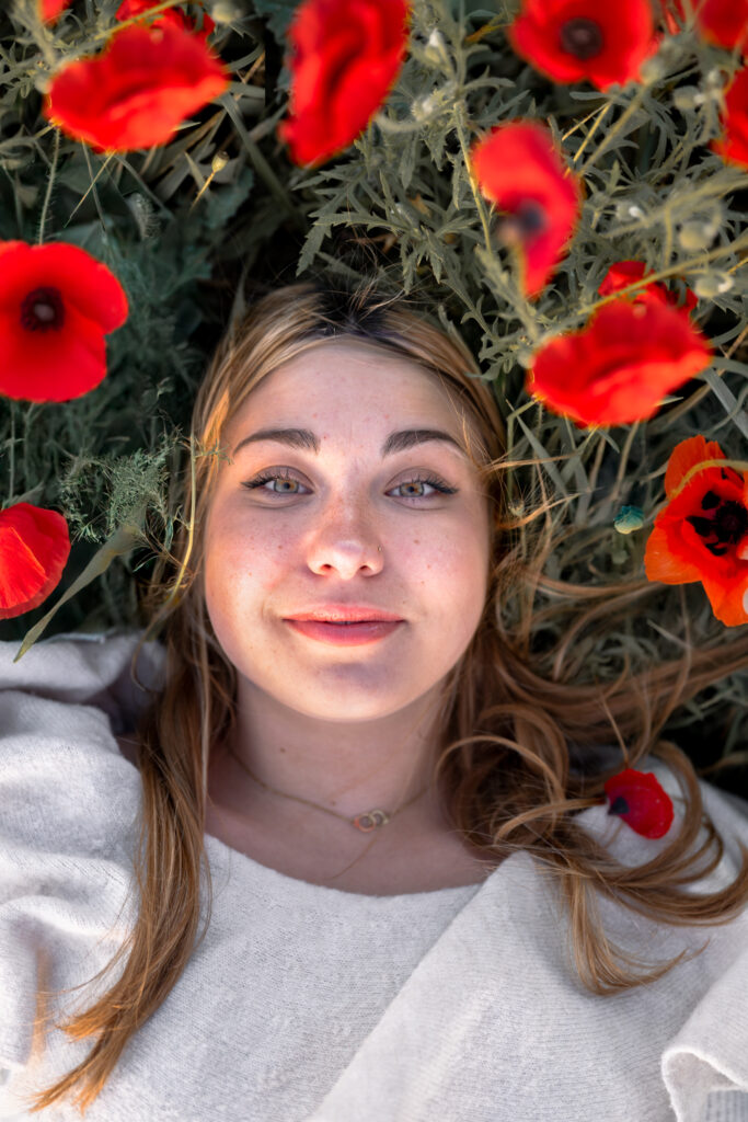 Photographe portrait Morez Jura Genève Lausanne Champagnole Lons-le-Saunier – portrait de femme allongée au milieu des coquelicots
