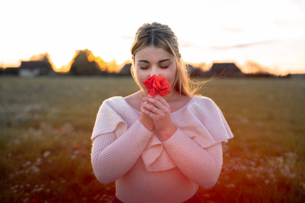 Photographe portrait Morez Jura Genève Lausanne Champagnole Lons-le-Saunier – femme tenant un coquelicot au coucher du soleil