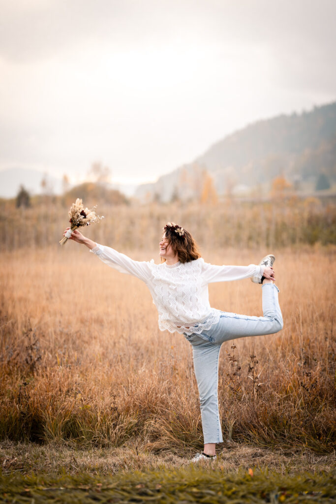 Photographe portrait Morez Jura Genève Lausanne Champagnole Lons-le-Saunier – femme en équilibre sur une jambe dans un champ d’herbes dorées