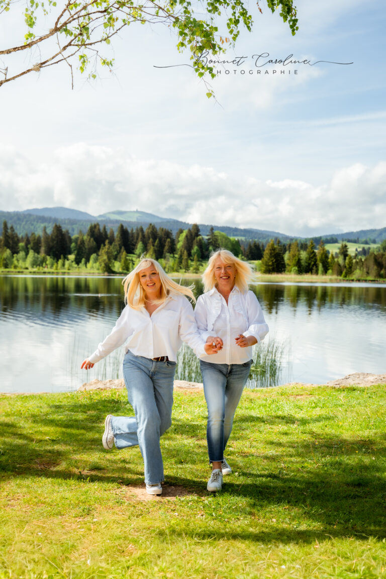 Séance photo famille dans le Haut-Jura : maman et sa fille courant au bord d’un lac