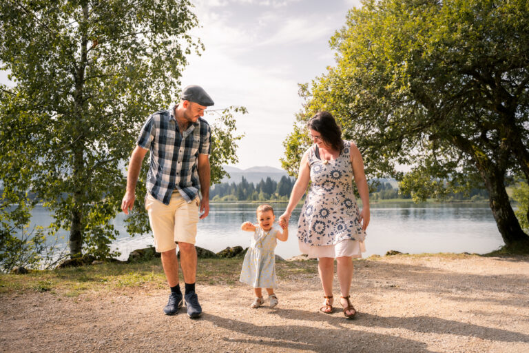 Séance photo famille dans le Haut-Jura : famille se promenant au bord d’un lac en été