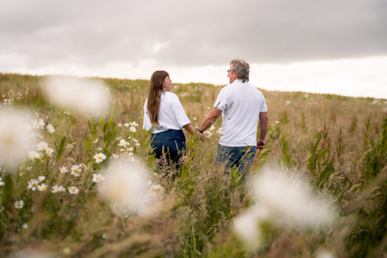 Séance photo famille en Normandie : papa et sa fille se promenant dans un champ de marguerites