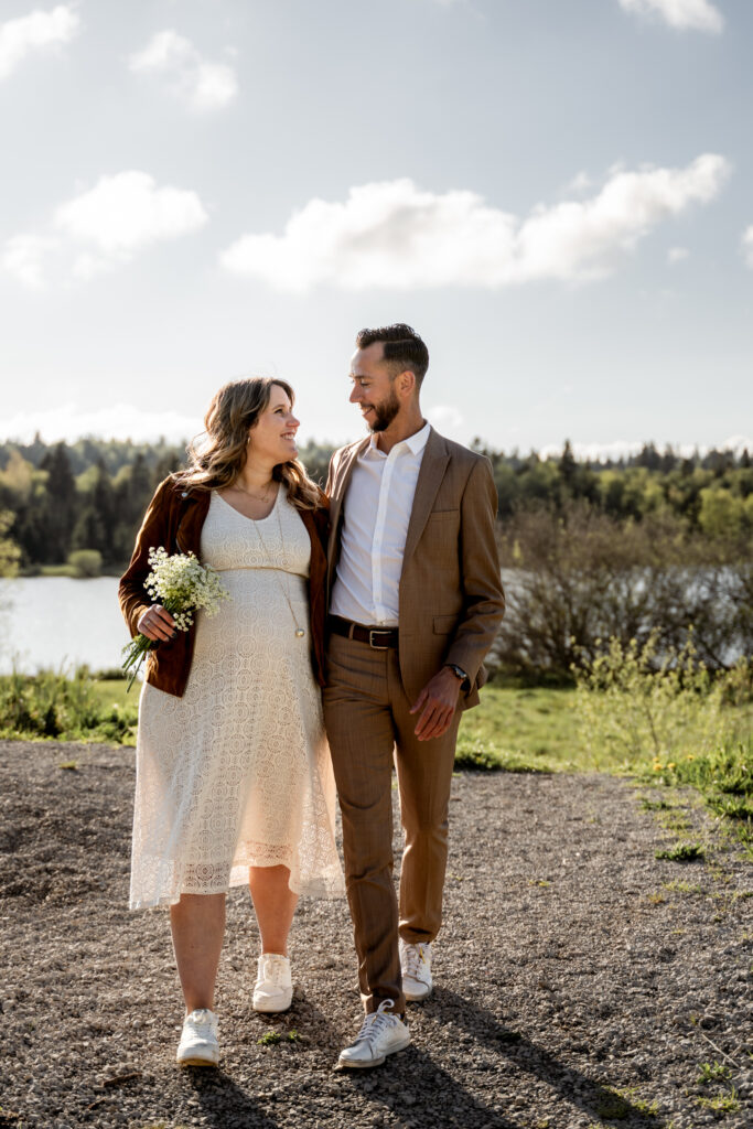 Photo de grossesse dans le Jura – couple main dans la main au lac de Bellefontaine