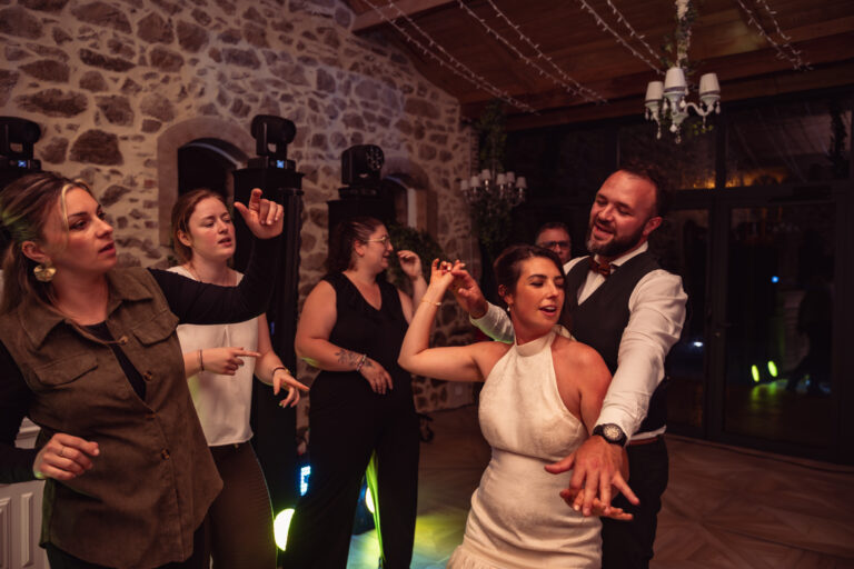 Photographe mariage Jura : mariée qui danse en riant avec ses invités