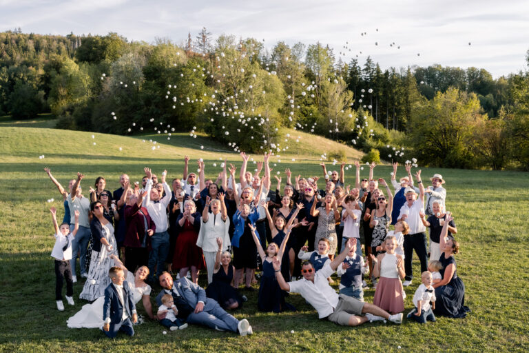 Photographe mariage Jura : grande photo de groupe des invités dans l’herbe