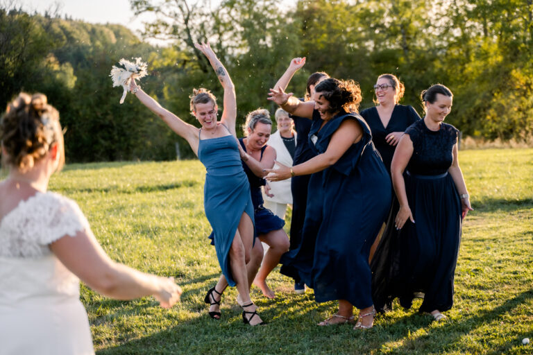 Photographe mariage Jura : invitées qui sautent pour attraper le bouquet
