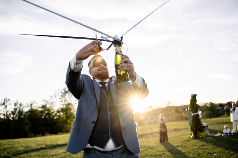 Photographe mariage Jura : invité qui joue avec un ruban à contre-jour
