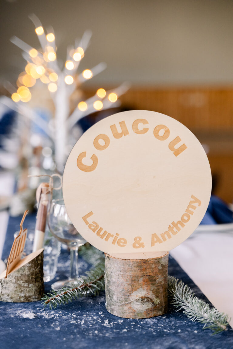 Photographe mariage Jura : panneau en bois « Coucou » des mariés sur un rondin