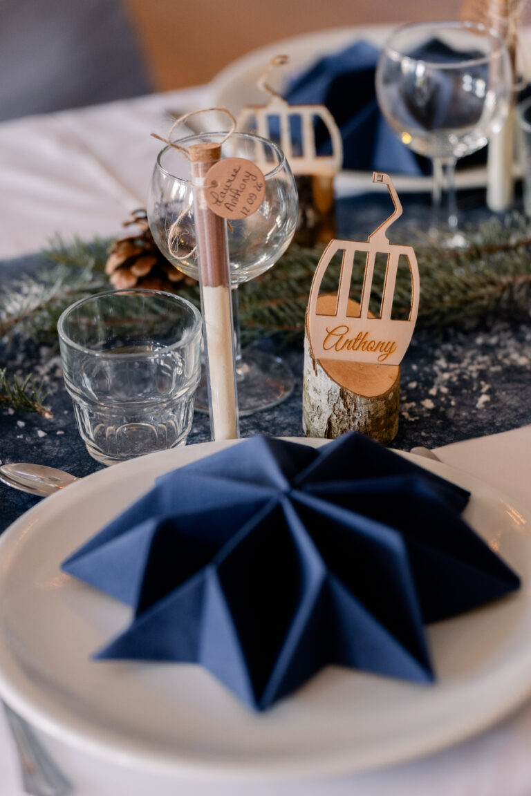 Photographe mariage Jura : serviette bleue pliée en étoile et marque-place en bois