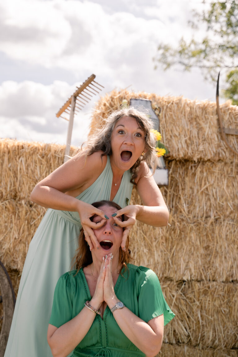Photographe mariage Jura : amies qui font des grimaces devant les bottes de paille